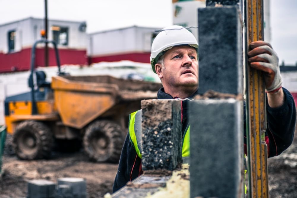 Contractor on worksite laying bricks for a business